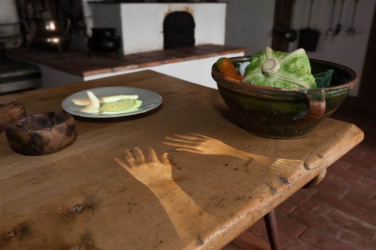 Esstisch auf Schloss Lenzburg mit projizierten Händen und Lebensmitteln.