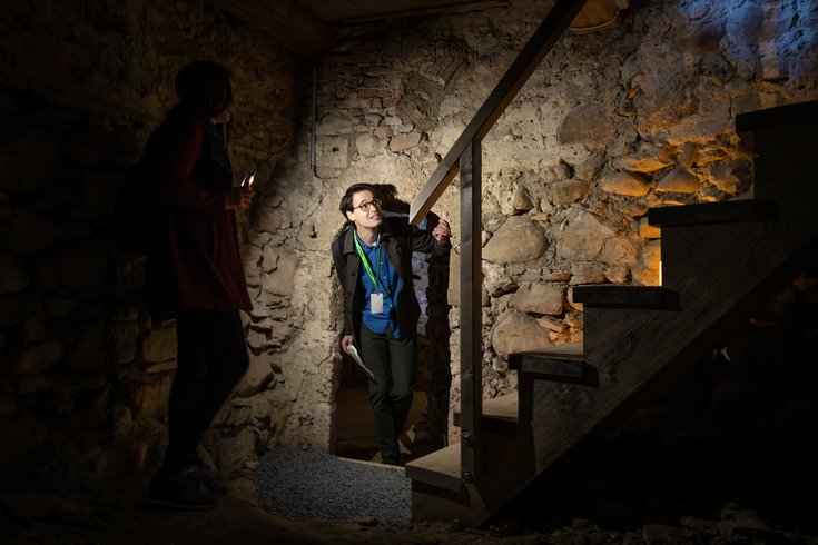 Ein Mann mit Foxtrail-Anhänger in einem mystischen Raum aus Steinen im Schloss Hallwyl.