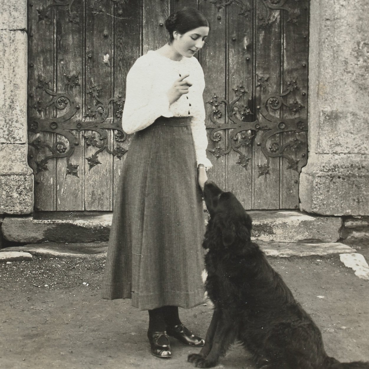 Eine Frau mit einem Hund vor dem Tor von Schloss Habsburg