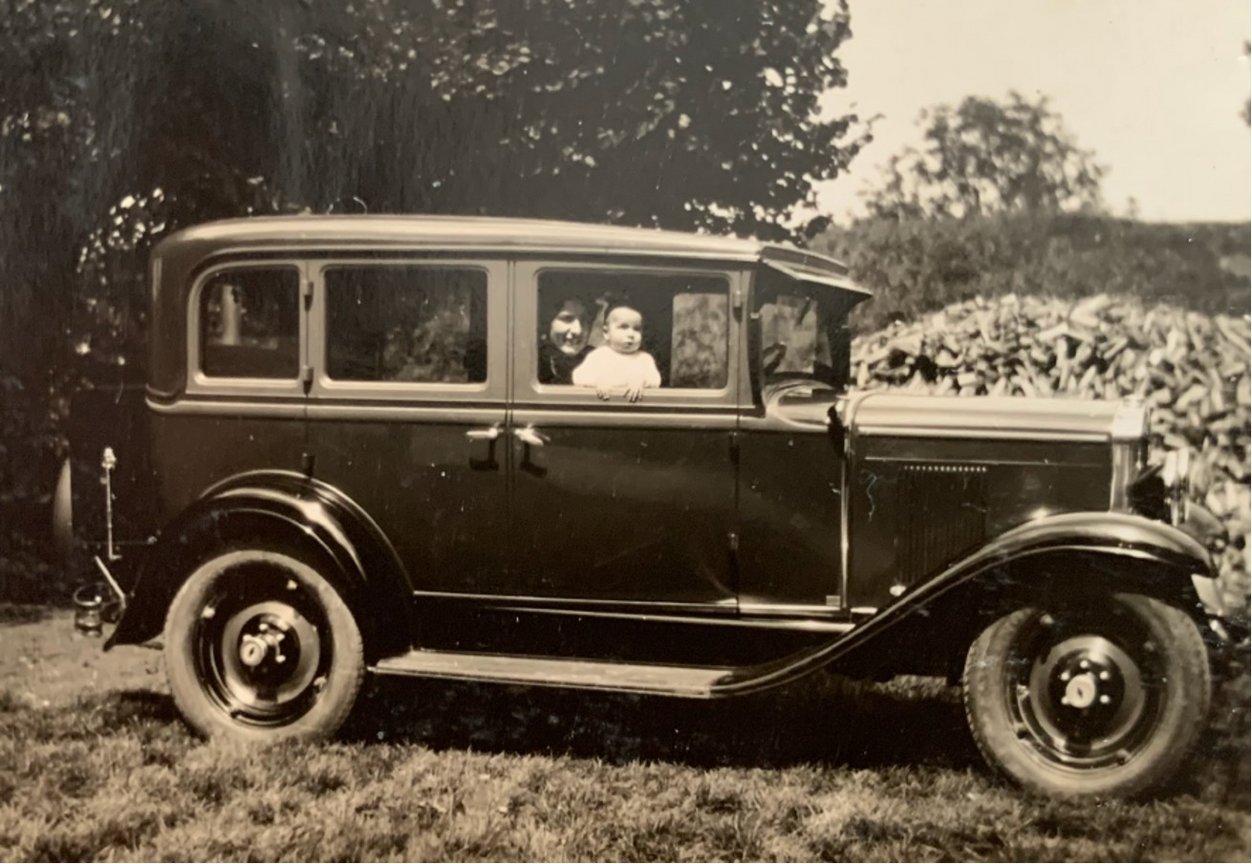 Eine Frau sitzt mit einem Kleinkind vorne in einem Chevrolet Al Capone