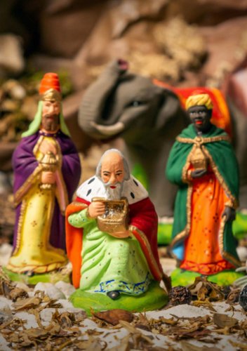 Bild von Krippenfiguren: Die Heiligen Drei Könige mit ihren wertvollen Gaben für das Jesuskind. Mit einem Elefant-Figur im Hintergund