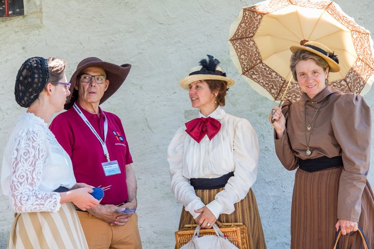 Ein Museumsführer mit Frauen,  die wie in der Belle Epoque gekleidet sind.