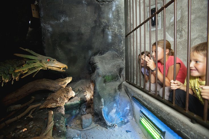 Schlossdrache Fauchi und drei Kinder in der Drachenhöhle von Schloss Lenzburg