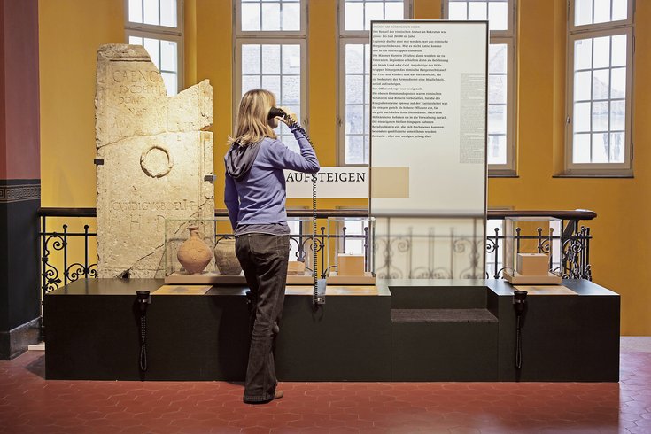 Besucherin hört Audioaufnahme zur Dauerausstellung im Vindonissa Museum