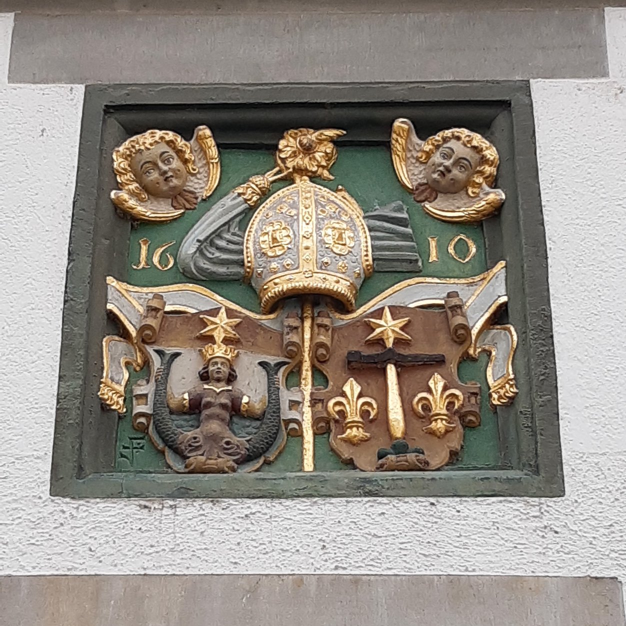 Darstellung des Wappens des Klosters: Meerjungfrau, Linien und Sternen.