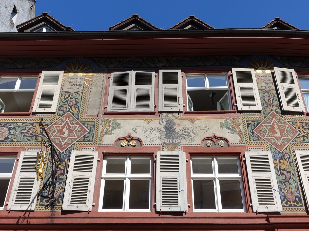 Bildausschnitt einer Hausfassade bemalt mit dem Firmenzeichen der ehemaligen Brauerei Salmenbräu.