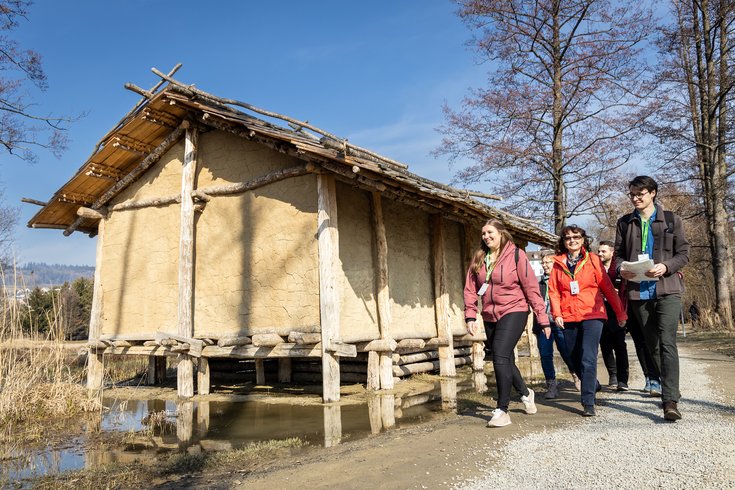 Eine Besuchergruppe mit Foxtrail-Anhängern beim Pfahlbauhaus am Hallwilersee in Seengen.