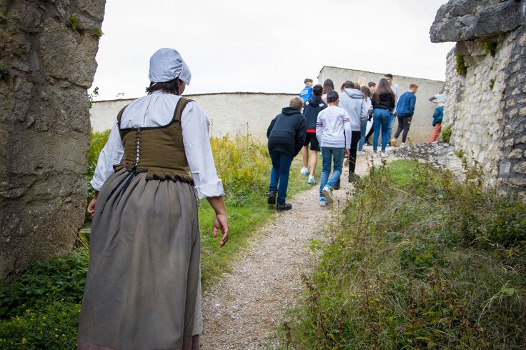 Eine Magd auf Schloss Wildegg; sie folgt einer Schulklasse ins Schloss