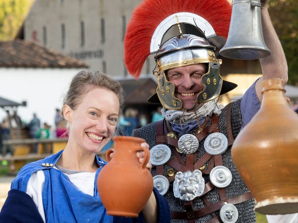Foto von einem Mann und einer Frau in römischer Kleidung mit Karaffen.