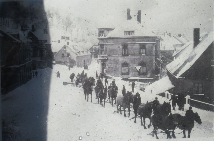 Schwarzweiss Foto. Winterimpression von Schönheide. 10 Pferden ziehen einen Schneepflug auf der Strasse. 