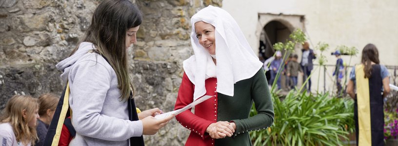 Verkleidete Margaretha von Hallwyl redet mit einer Schülerin im Workshop Adlerflug im Schloss Hallwyl .
