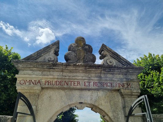 Foto vom Gartenportal. Detail Inschrift: "Omnia prudenter et recepie finem"