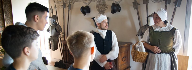 Ein Knecht und eine Magd mit Schulklasse im Wohnmuseum von Schloss Wildegg
