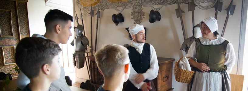 Ein Knecht und eine Magd mit Schulklasse im Wohnmuseum von Schloss Wildegg
