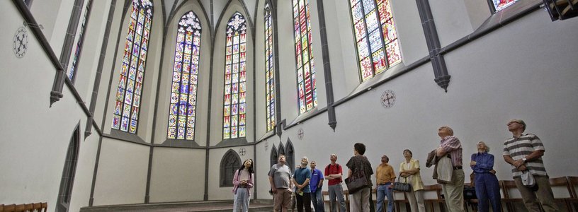 Besucher und Besucherinnen bei der Führung im traumhaften Kloster Königsfelden mit Glasfenstern