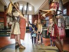 Drei Mädchen stehen in der Ausstellung im Vindonissa Museum. Vor ihnen stehen zwei lebensgrosse Legionäre (Figuren)