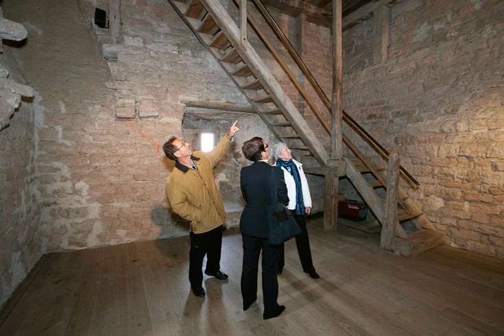 Drei Besucher*innen betrachten die Wände vom Schloss Habsburg