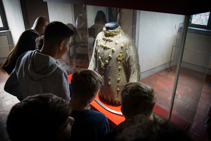 Mehrere Schüler betrachten ein Kettenhemd in der Ausstellung von Schloss Wildegg
