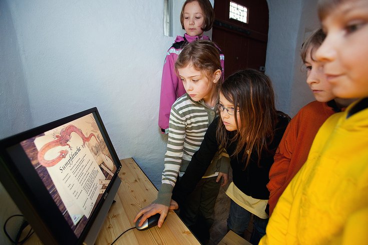 Kinder in der Ausstellung "Drachenforschungsstation" über Drachen auf Schloss Lenzburg