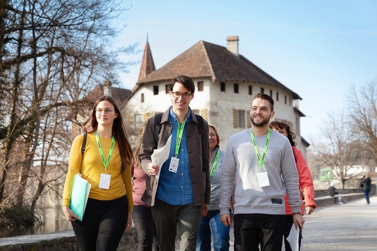 Eine Besuchergruppe mit Foxtrail-Anhängern, im Hintergrund Schloss Hallwyl