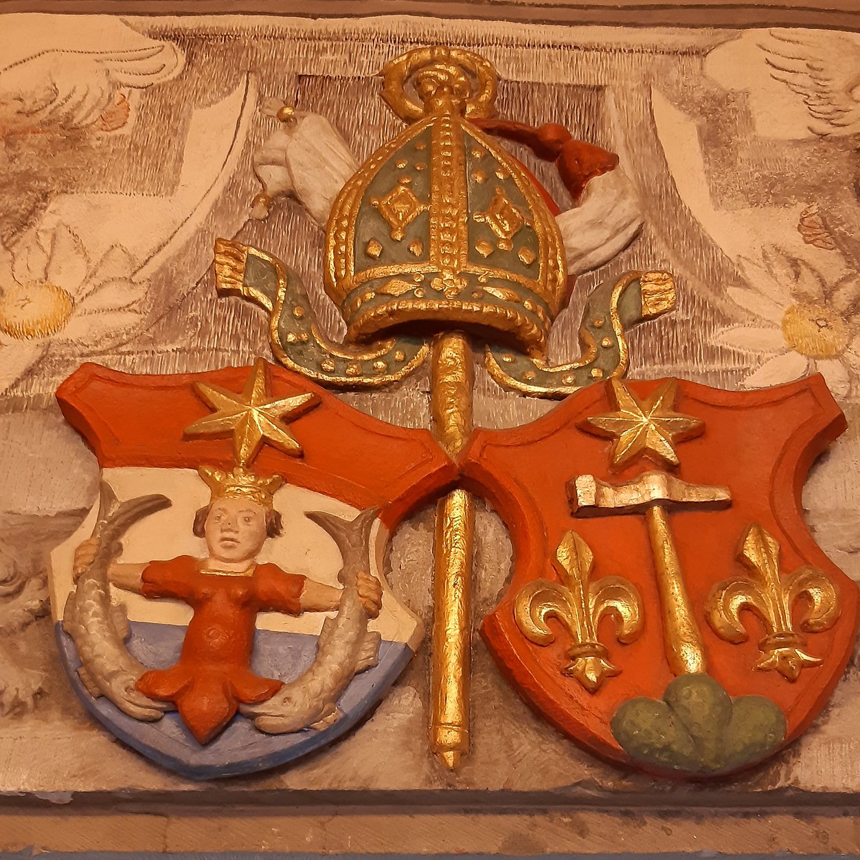 Wappen des Klosters: Meerjungfrau und Hammer mit Sternen und Lilien.
