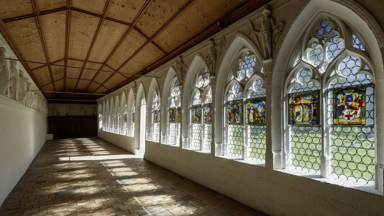 Kreuzgang im Kloster Wettingen, das Licht wirft durch die Fenster lange Schatten in den Gang.